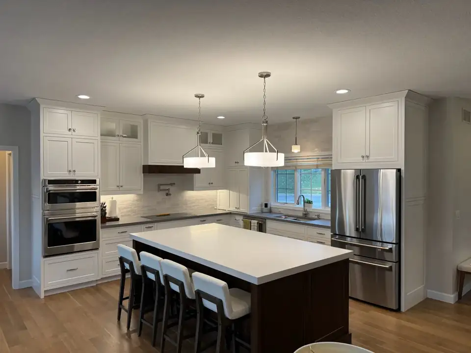 Kitchen remodeling Rochester MN project by Goldsmith Remodel and Design: white shaker cabinets, dark stained island with seating, white quartz counters and drum pendant lights