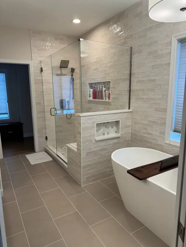Primary bathroom remodel with freestanding soaking tub, frameless glass walk-in shower, tiled niche and porcelain plank floor